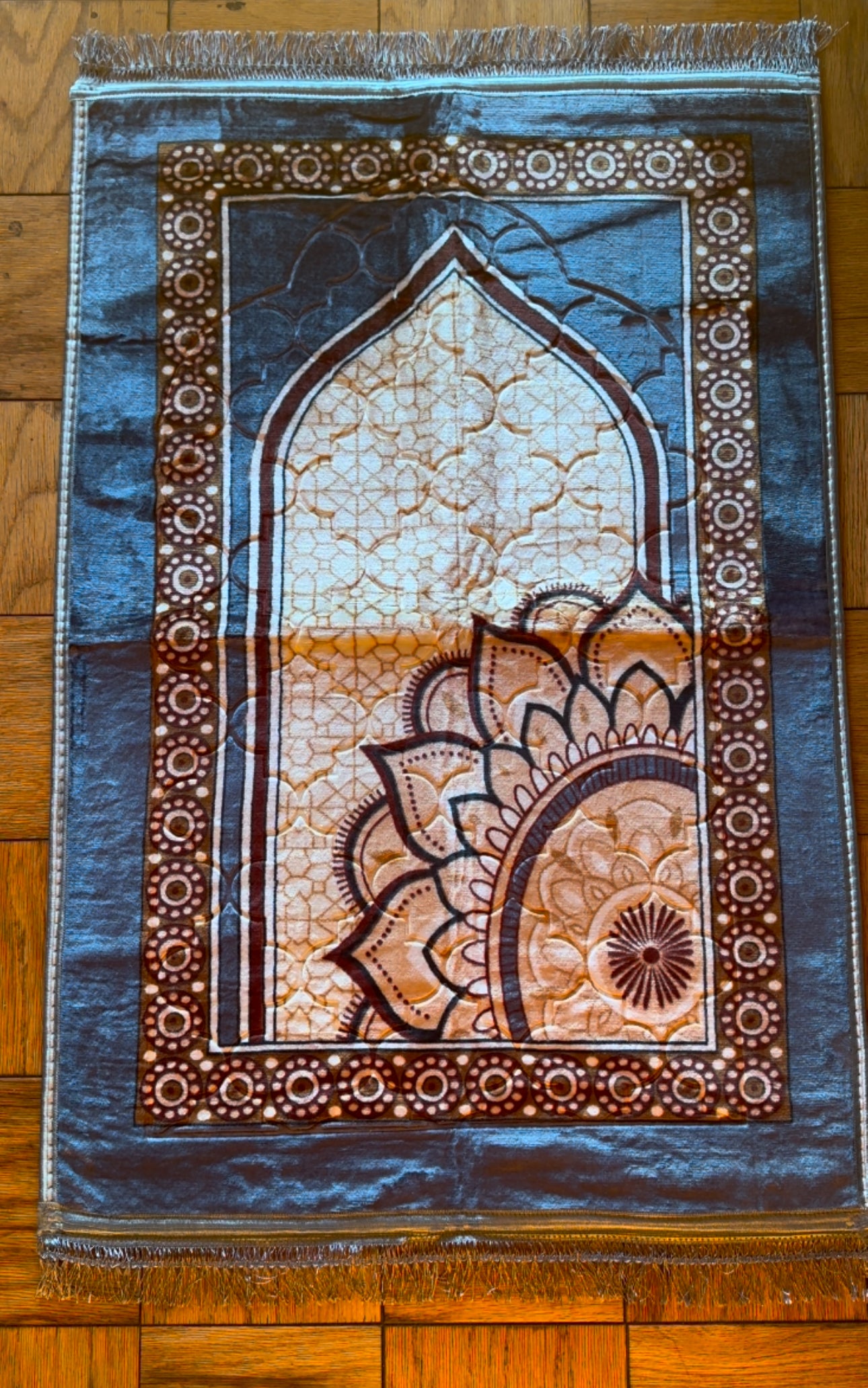 A selection of Premium Velvet Prayer Mats in various colors displayed on the floor, each featuring intricate patterns and a non-slip design.