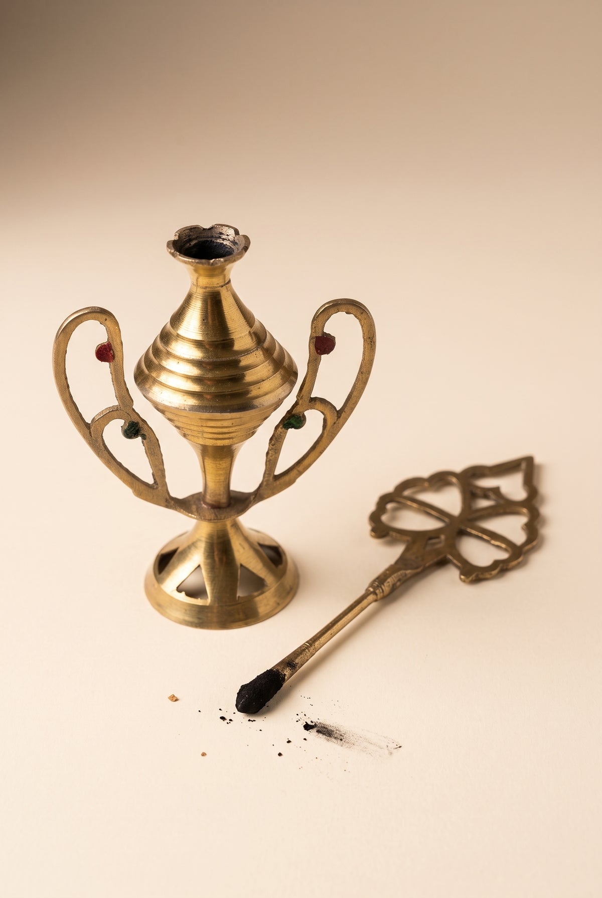 Vintage kohl applicator shown open with its ornate applicator stick tipped with kohl