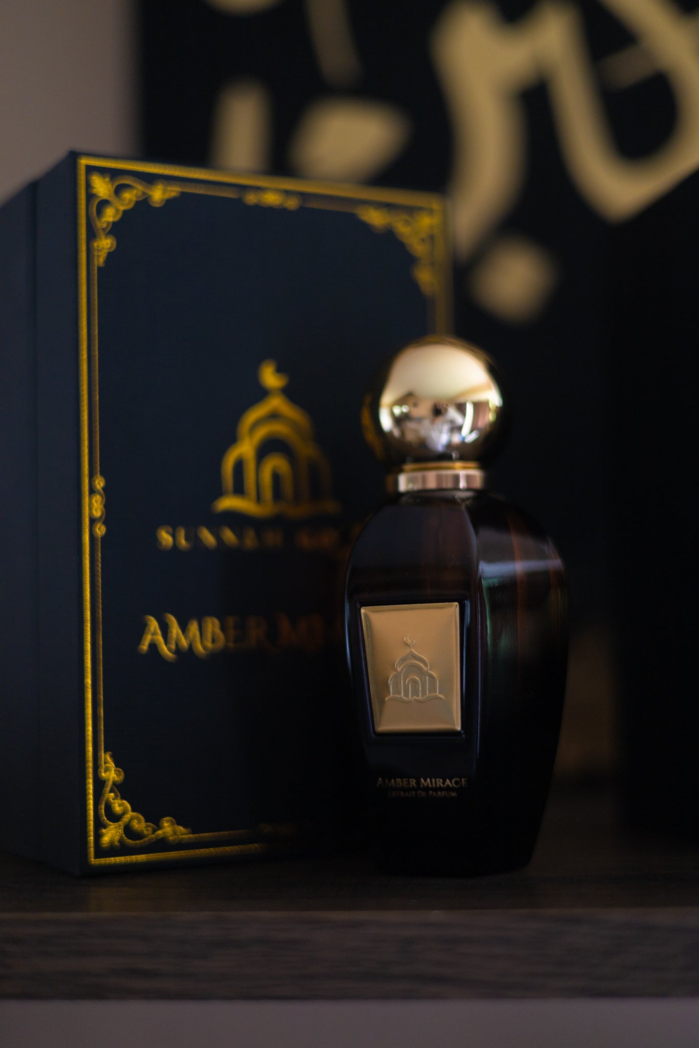 Perfume bottle and packaging with gold accents on a dark background