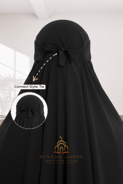 Black abaya with a bow detail on a white background, featuring the Sunnah Goods logo.