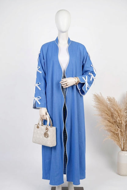 Blue open abaya with white ribbon bow sleeves on a mannequin