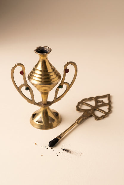 Vintage kohl applicator shown open with its ornate applicator stick tipped with kohl