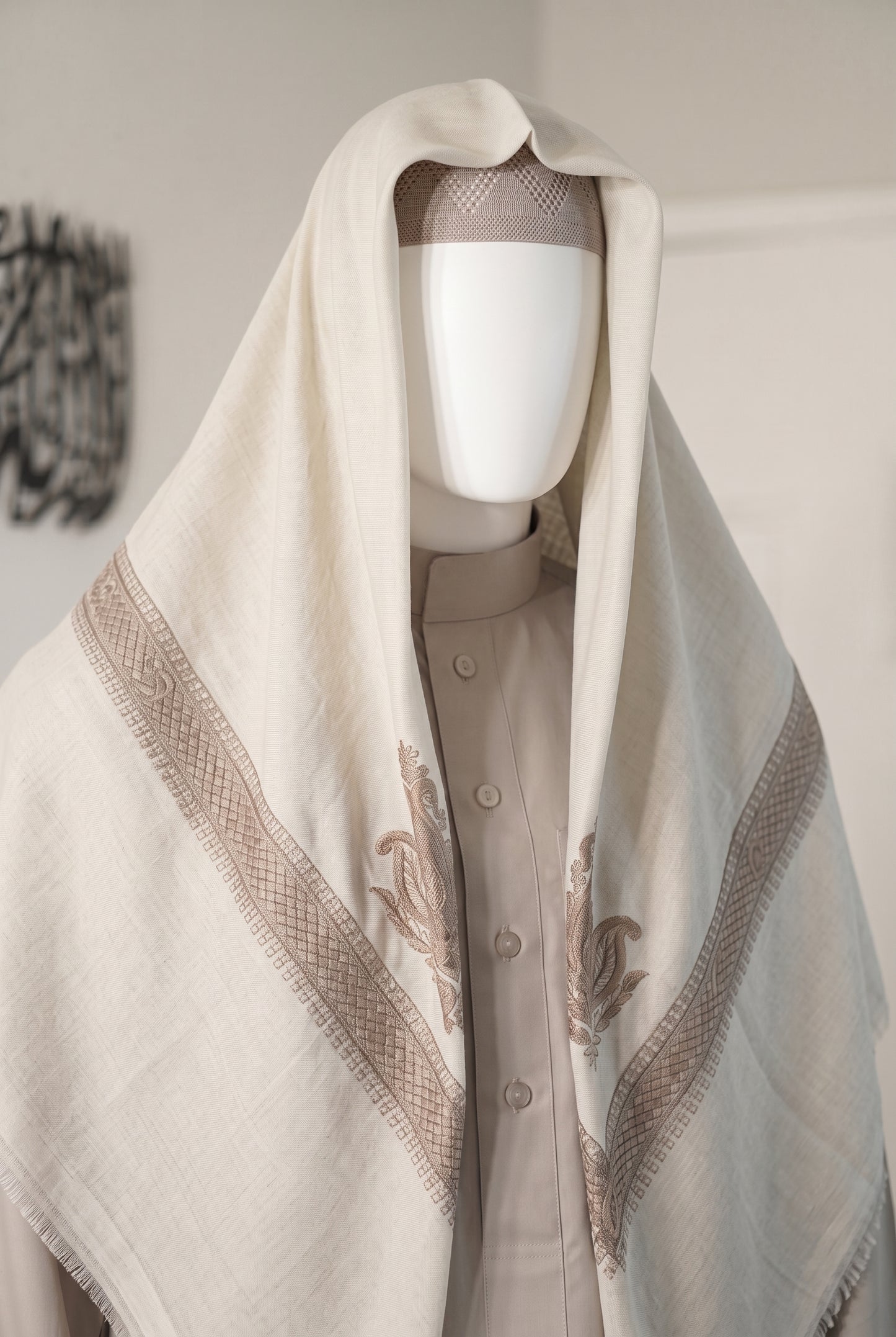 Pearl white shemagh with navy embroidered trim draped on mannequin