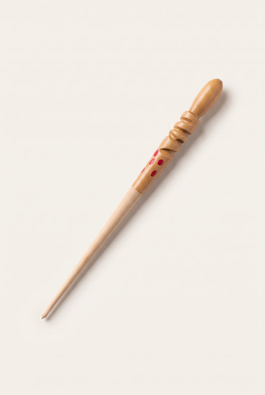 Traditional wooden kohl stick applicator with a carved handle and red dot details