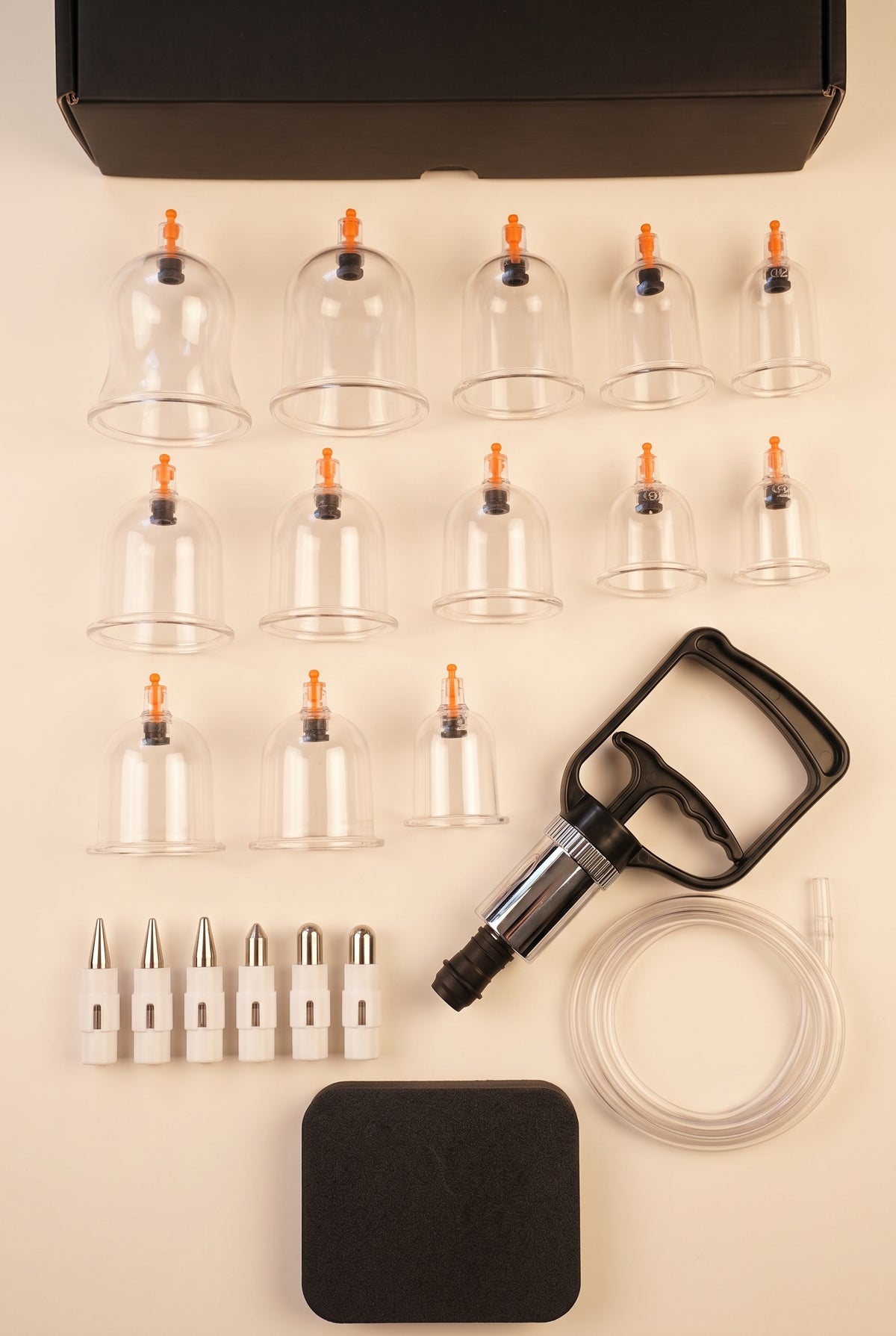 Everything in the Theracups hijama set: 12 cups, hand pump, extension hose, pressure point attachments and massage board