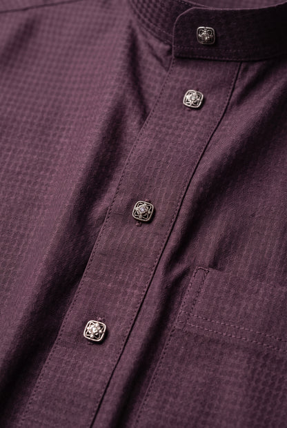 Close-up of the textured burgundy fabric and buttons on an Al Aseel winter thobe