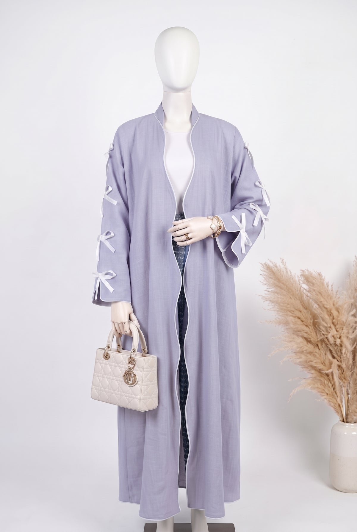 Lavender open abaya with white ribbon bow sleeves on a mannequin