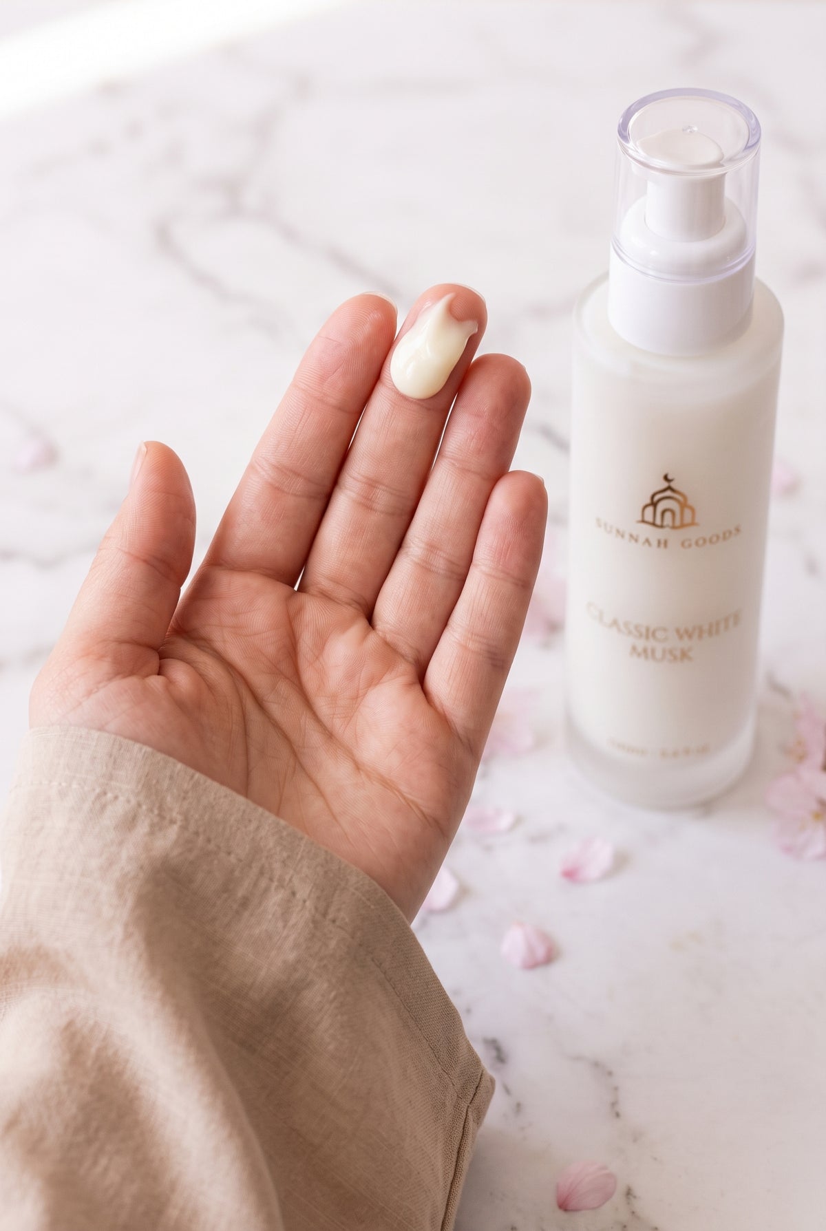 Rich, creamy white Musk Al Tahara lotion on a woman's fingertips, showing its thick texture