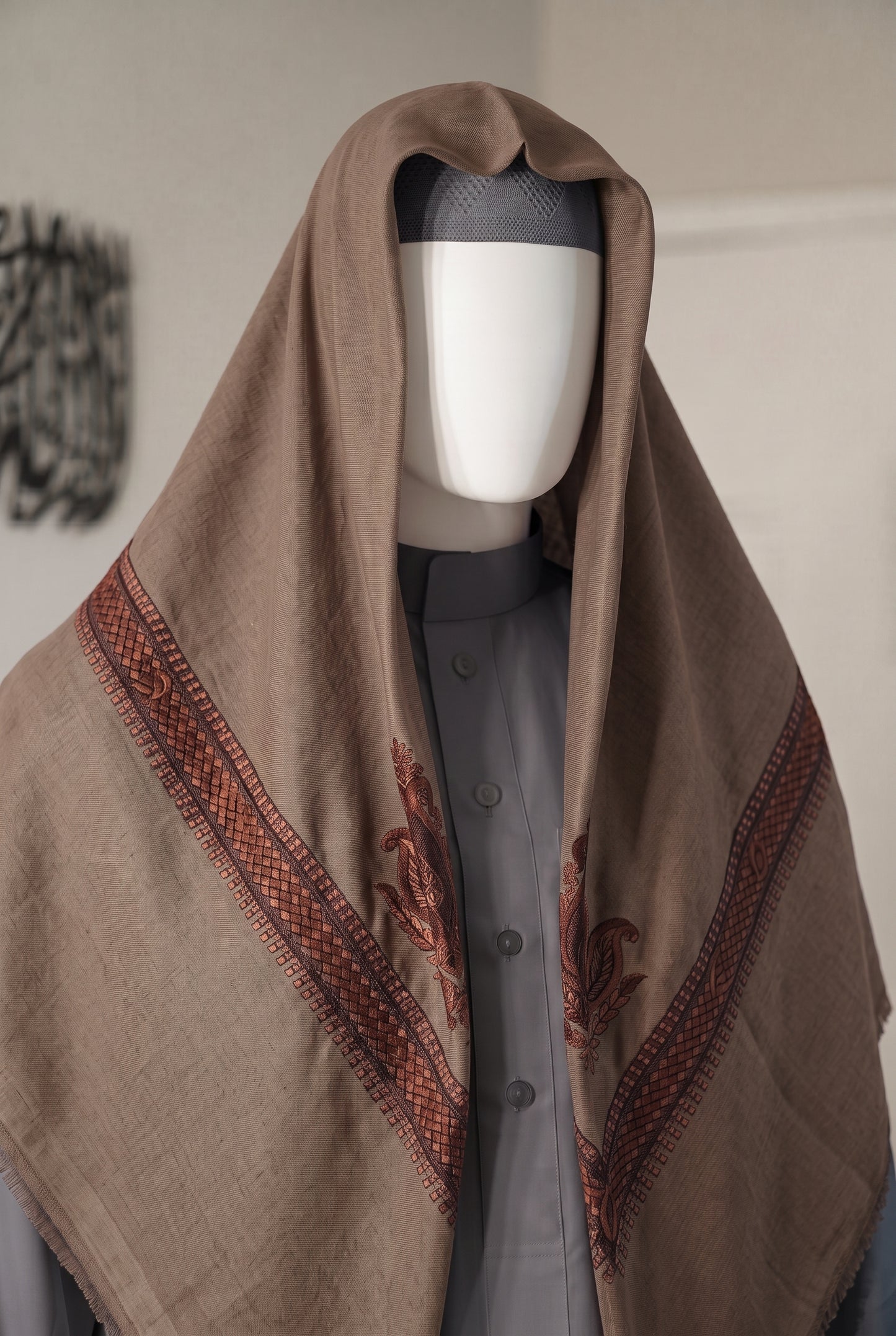 brown shemagh with silver embroidery draped on mannequin with matching kufi and thobe