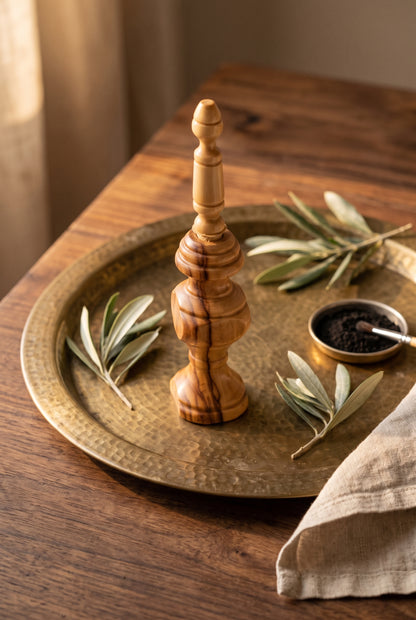 Olive wood kohl applicator on a round brass tray with olive leaves and kohl powder