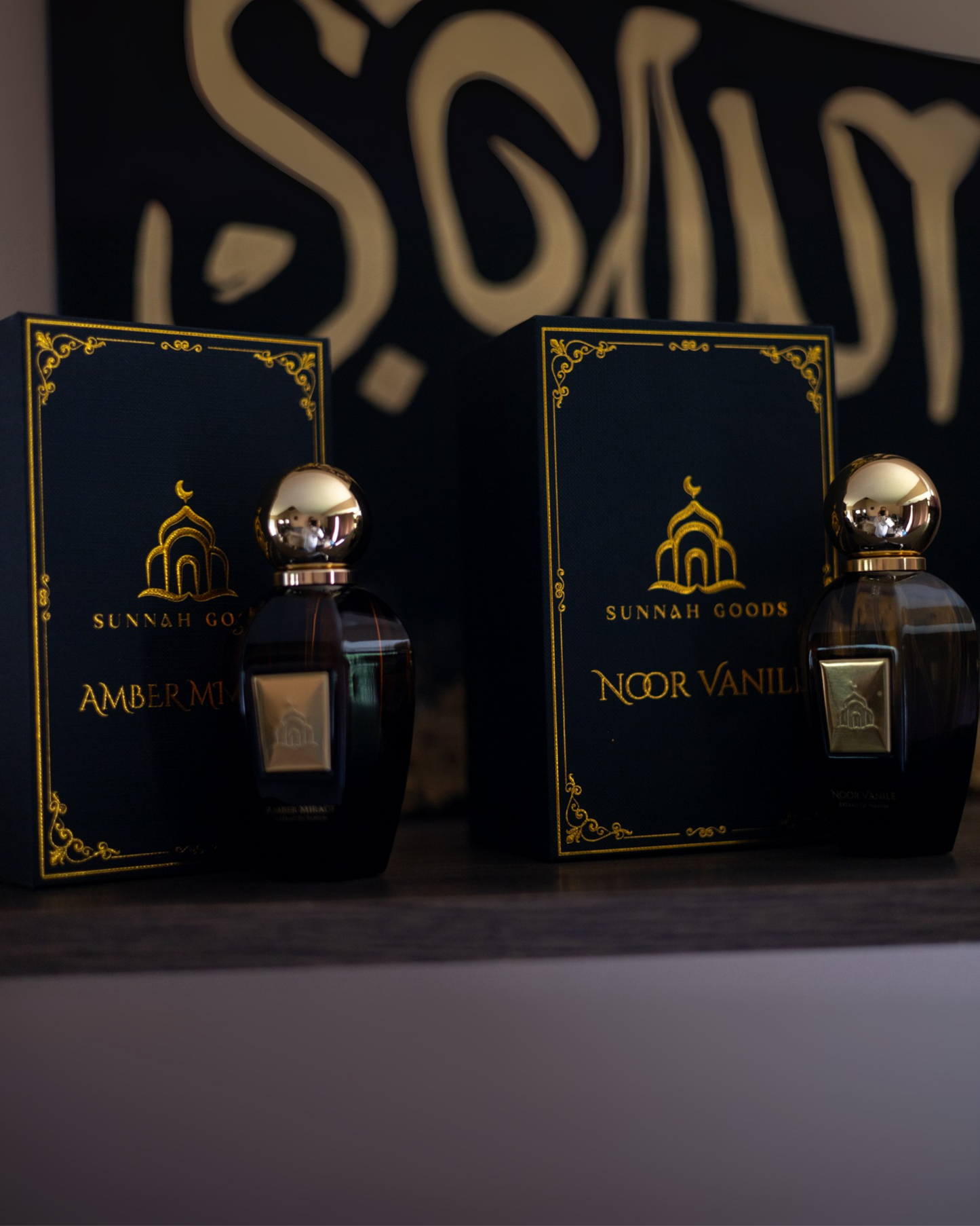 Two bottles of Sunnah Goods perfume with their packaging in front of a dark background.